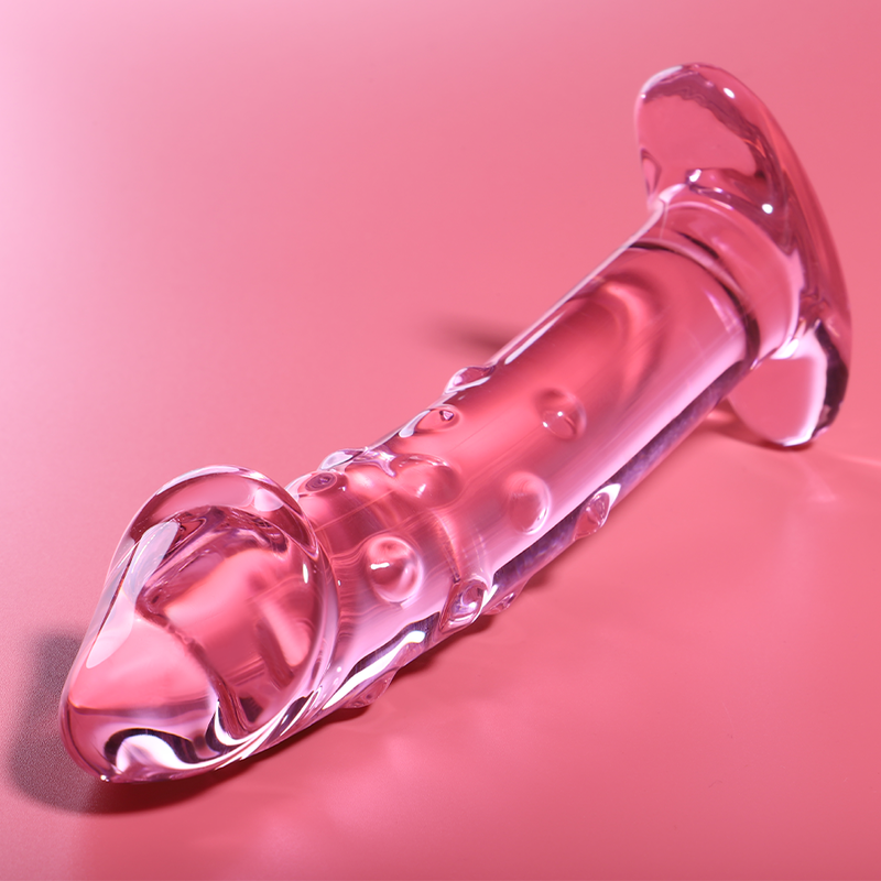 Gode en verre borosilicate rose couche sur fond corail, forme realiste a gland et veines en relief, base evasee brillante, sextoy non poreux a jeu de temperature.