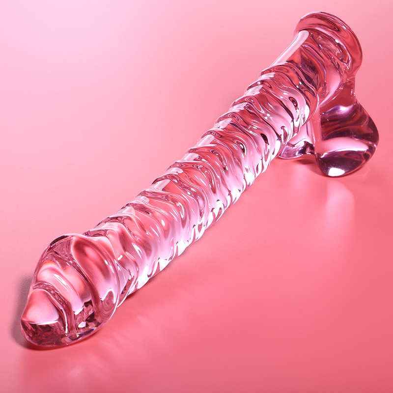 Gode en verre borosilicate rose couche sur fond corail, forme realiste a gland, veines en relief et base testiculaire brillante, sextoy non poreux thermique.