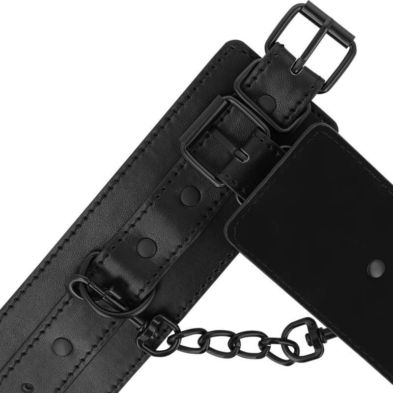 Gros plan d'une menotte en cuir synthétique Intense Fetish, boucle de réglage et chaine de liaison noire détaillées. Attache confortable pour le bondage.