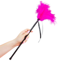 Plumeau tickler Secret Play en plumes fuchsia tenu en main par le manche noir, accessoire de caresse sensorielle pour eveiller la peau et raviver les preliminaires.