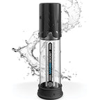 Pompe à pénis Max Boost debout dans une éclaboussure d'eau, tube transparent gradué et tête noire à piston, visuel dynamique soulignant son côté étanche.