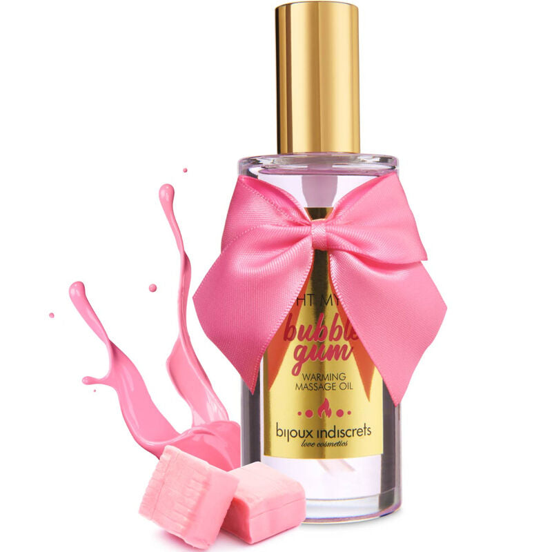 Flacon huile de massage Bubble Gum Bijoux Indiscrets a noeud satin rose avec eclaboussure de gel et bonbons roses, mise en scene gourmande du cosmetique chauffant