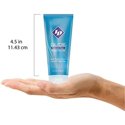 Tube ID Glide Natural Feel pose sur une main, repere d'echelle 11,43 cm, lubrifiant base eau format voyage glisse soyeuse compatible sextoys