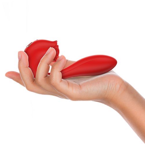 Stimulateur Selena en silicone rouge ultra doux tenu dans une main, illustrant le format compact a deux moteurs avec tete d'aspiration en rose et tige de stimulation incurvee.