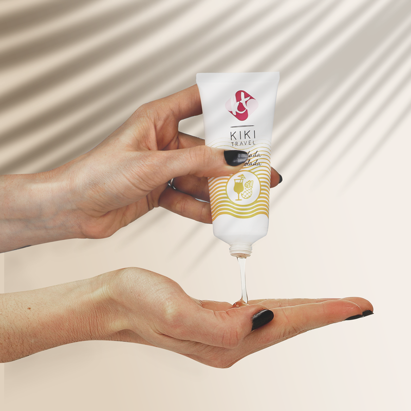 Demonstration du lubrifiant Kiki Travel Pina Colada verse sur une main, texture fluide base eau longue duree, formule comestible vegan a l'aloe vera sans sucre.