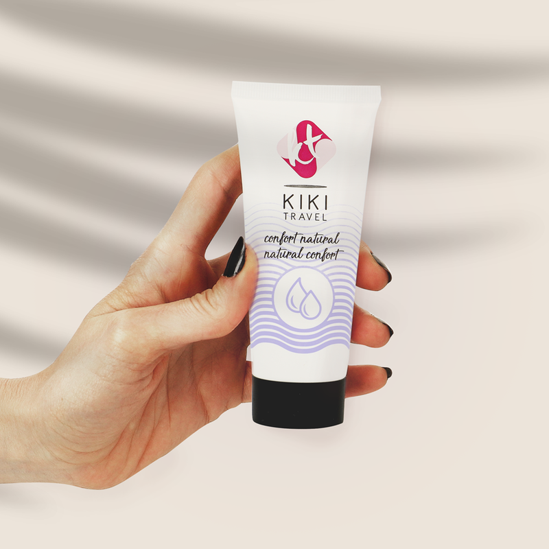 Tube de lubrifiant base eau Kiki Travel confort naturel tenu en main pour montrer son format compact, formule hydratante vegan douce, compatible preservatifs et sextoys.