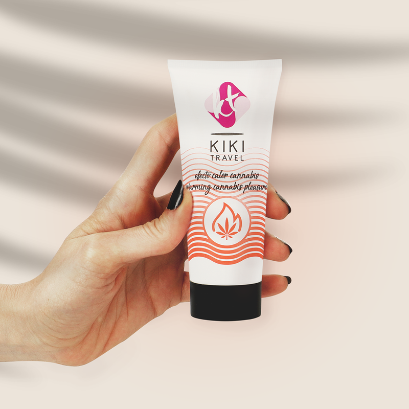 Tube de lubrifiant chauffant arome cannabis Kiki Travel tenu en main pour montrer son format compact, base eau vegan effet chaleur, compatible preservatifs latex et sextoys.