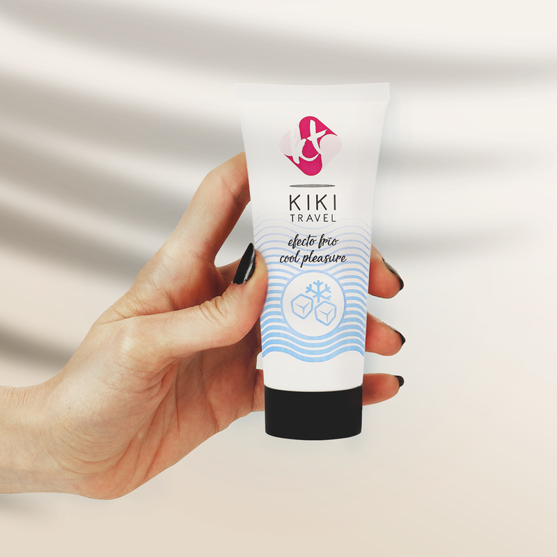 Tube de lubrifiant effet froid Kiki Travel tenu en main pour montrer son format compact, base eau fraicheur vegan, sensation cooling, compatible preservatifs latex et sextoys.