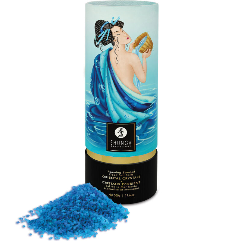 Bain sensuel Shunga en tube illustré turquoise, cristaux bleus répandus devant, perles aromatiques se transformant en gel hydratant pour parfumer le bain et détendre la peau.