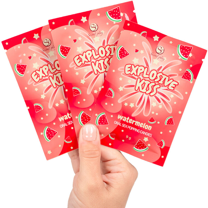 Trois sachets de bonbons explosifs Explosive Kiss saveur pasteque tenus en eventail. Friandises petillantes comestibles a usage unique pour des jeux oraux gourmands.