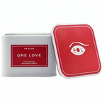 Bougie de massage carree One Love fermee avec son couvercle rouge pose a cote, bougie aux pheromones 150 ml rose jasmin vanille Eye Of Love.