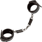 Manchettes de cheville Euphoria noires reliées par une chaîne à mousquetons pivotants, sangles ouvertes à plat sur fond blanc.