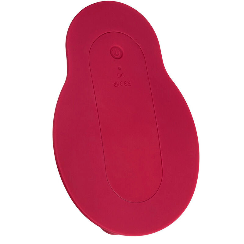 Rider Massager rouge foncé posé à côté de sa télécommande ovale, logo XO CalExotics visible sur la télécommande.