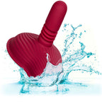 Rider Massager rouge foncé en suspension dans une éclaboussure d'eau, illustrant l'étanchéité du produit.
