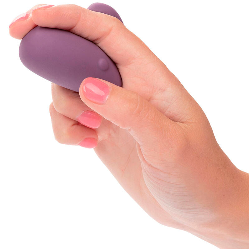 Stimulateur Mod Touch violet tenu en main, démonstration de la prise en paume avec bouton visible sous le pouce.