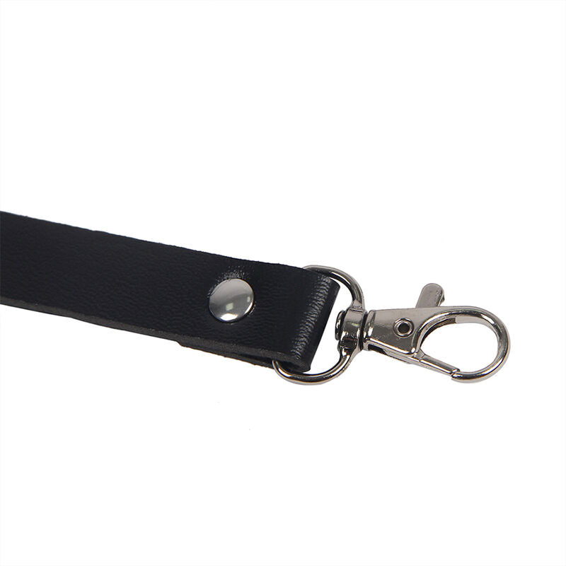Gros plan d une sangle en cuir noir avec bouton pression et mousqueton metal du harnais de corps Subblime, finition robuste et ajustable.