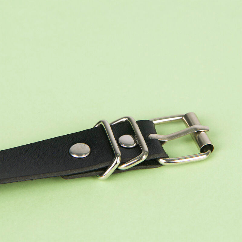Gros plan de la boucle metal et de la sangle en cuir noir de la ceinture chaine Subblime, fermeture ajustable robuste au rendu fetichiste.