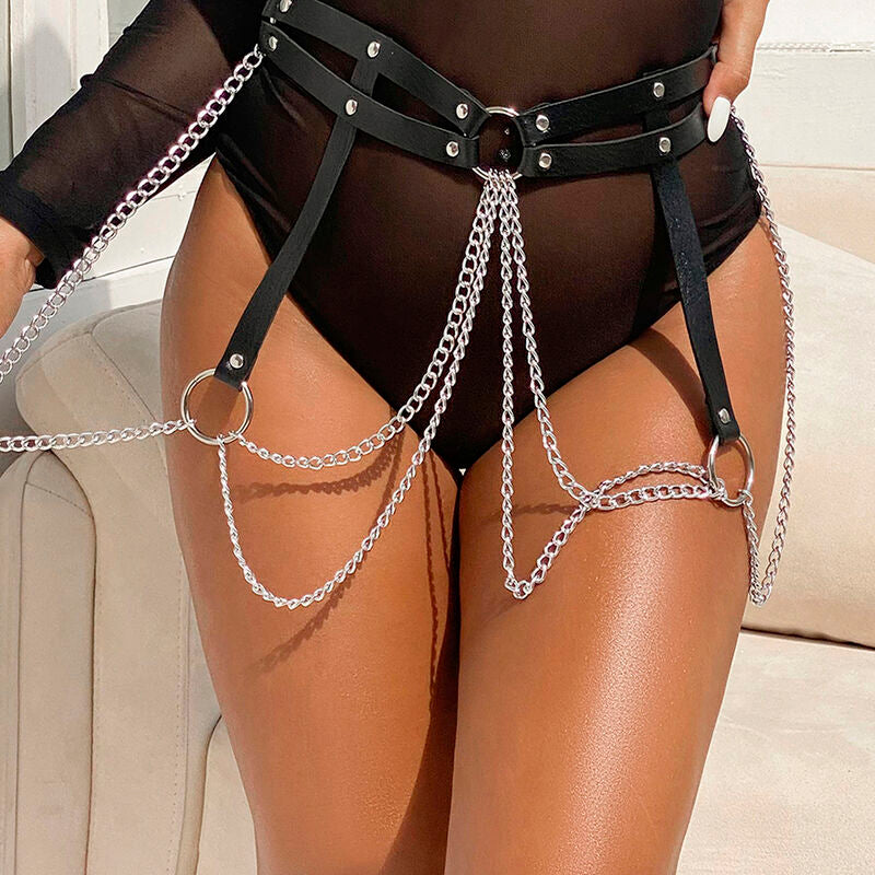 Harnais de taille et de jambes en cuir noir a chaines porte sur les cuisses denudees, structure fetichiste reliant hanches et cuisses signee Subblime.