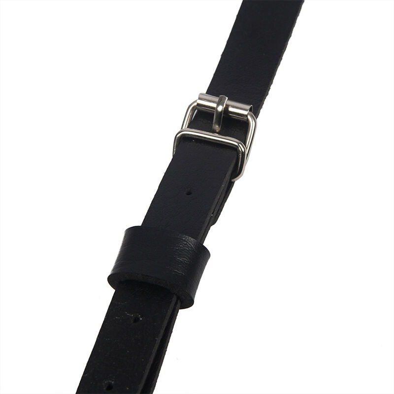 Detail de la boucle metal et de la sangle en cuir noir du harnais de poitrine Subblime, fermeture ajustable au rendu fetichiste robuste sur fond clair.