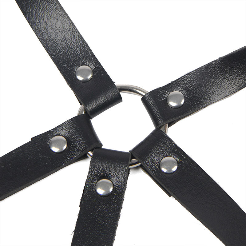 Detail de l anneau metal central reliant les sangles en cuir noir du harnais de poitrine Subblime, jeu graphique fetichiste presente sur fond blanc.