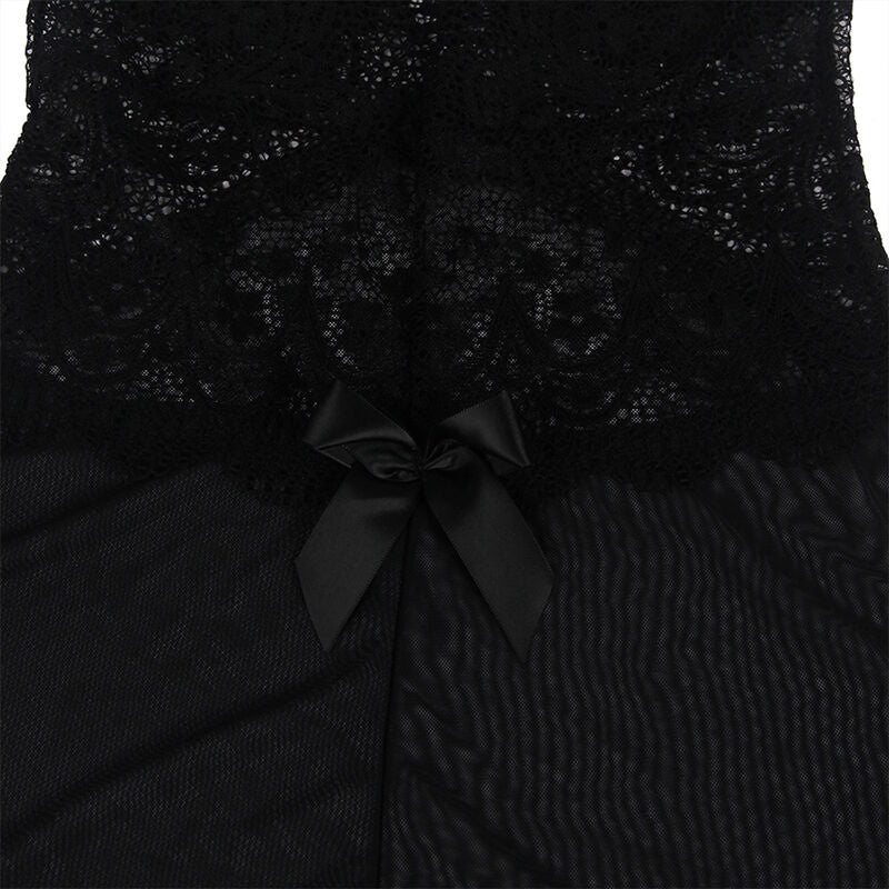 Détail de la dentelle florale et du noeud satiné du babydoll noir Subblime à plat, broderie festonnée et tulle transparent en gros plan sur fond sombre.