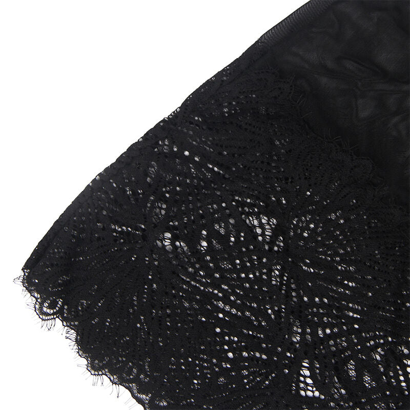 Gros plan sur le volant inferieur en dentelle florale ajouree de la nuisette noire Subblime, motifs fleuris festonnes, tissu pose a plat sur fond blanc.