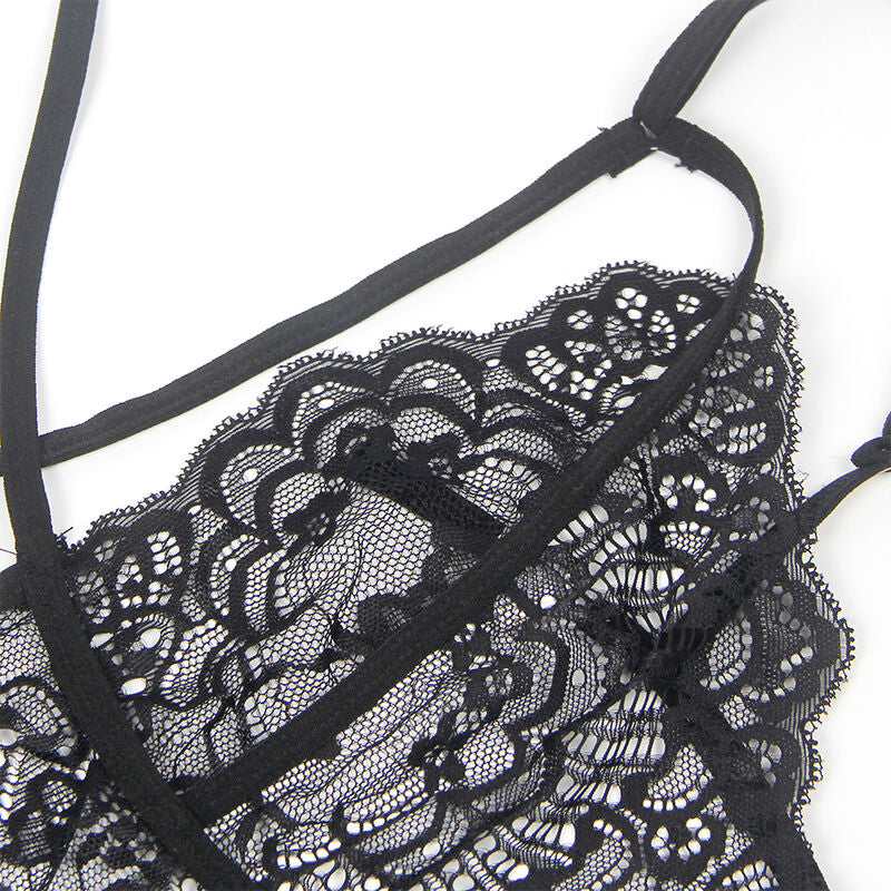 Detail rapproche de la dentelle noire a motif floral et des sangles fines du body police Subblime sur fond clair.