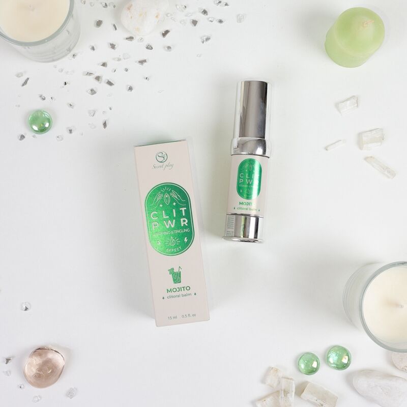 Baume stimulant clitoris Clit Pwr Mojito presente avec sa boite verte parmi des cristaux et bougie. Soin chauffant picotant 15 ml en flacon airless pour le plaisir feminin.