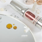 Gouttes du baume Clit Pwr menthe chocolat deposees sur un miroir pres du flacon airless. Gel stimulant clitoris a effet chauffant et picotant, absorption rapide, usage externe.
