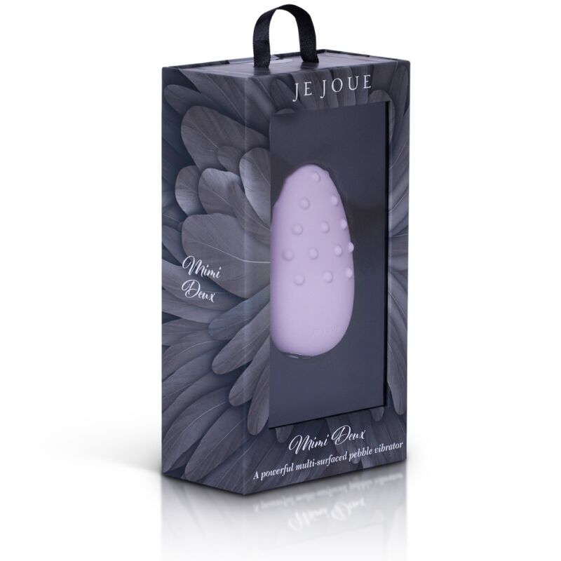 Coffret Mimi Deux Je Joue vu de face, galet lilas à picots bien visible dans la vitrine sur fond de plume sombre, libellé Mimi Deux imprimé en pied du packaging sur fond blanc épuré.