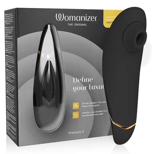 Boîte grise du Womanizer Premium 2 et stimulateur clitoridien noir au liseré doré, embout d'aspiration en silicone, technologie Pleasure Air sans contact.