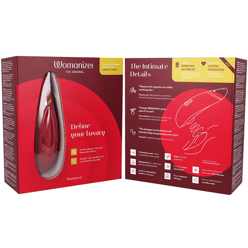 Emballage rouge du Womanizer Premium 2 ouvert présentant le device et un schéma d'usage du stimulateur clitoridien par ondes d'air, sans anatomie. Visuel pédagogique non explicite.