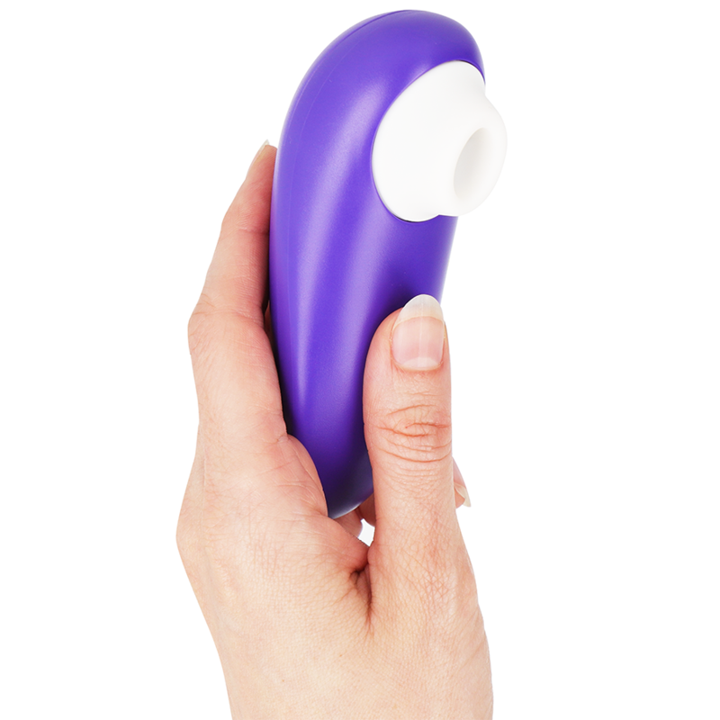 Stimulateur clitoridien Womanizer Starlet 3 violet tenu à la verticale dans une main, embout d'aspiration blanc en silicone orienté vers le haut. Format ergonomique compact.