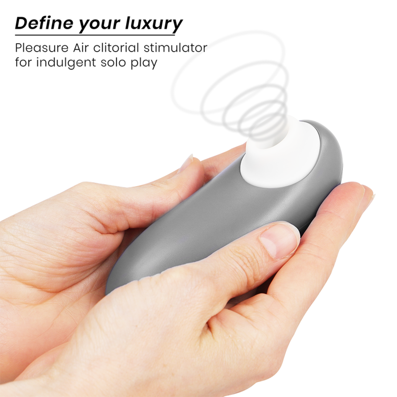 Main tenant le Womanizer Starlet 3 gris, embout d'air pulsé blanc vers le haut et schéma d'ondes d'air pour stimulation clitoridienne sans contact. Format ergonomique compact.