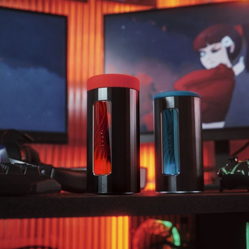 Deux masturbateurs Lelo F1S V3 poses sur une etagere dans un decor gaming illustre, consoles de plaisir connectees fermees sans element anatomique.