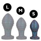 Comparatif des trois tailles L, M et S du plug œuf de dragon en silicone ecailleux gris bleute, formes bulbeuses sur cols evases pour une prise sure.
