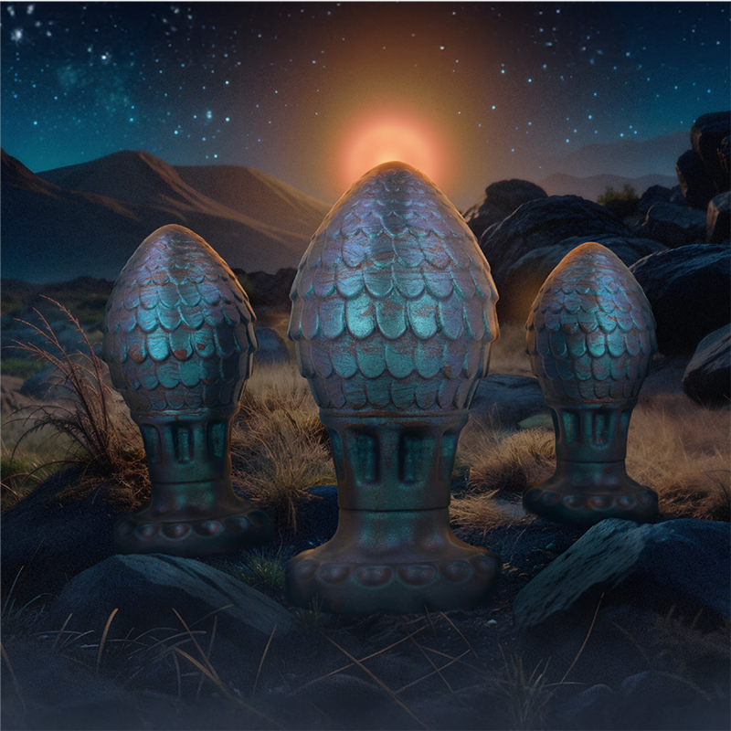 Trois plugs œufs de dragon ecailleux bleu vert mis en scene dans un paysage nocturne, silicone fantasy soulignant les tailles graduees de la gamme.