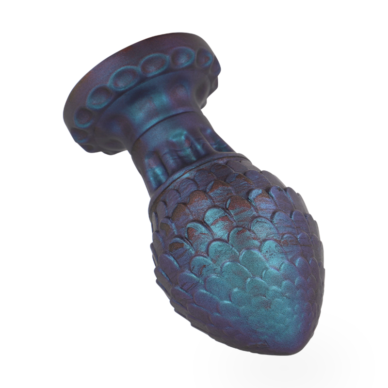 Plug œuf de dragon en silicone ecailleux bleu vert presente couche de trois quarts, base large evasee visible, texture coquille pour une stimulation douce.