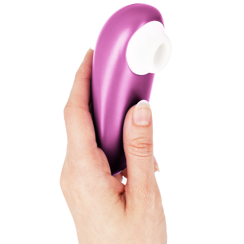 Stimulateur clitoridien Womanizer Starlet 3 fuchsia tenu à la verticale dans une main, embout d'aspiration blanc en silicone orienté vers le haut. Format ergonomique compact.