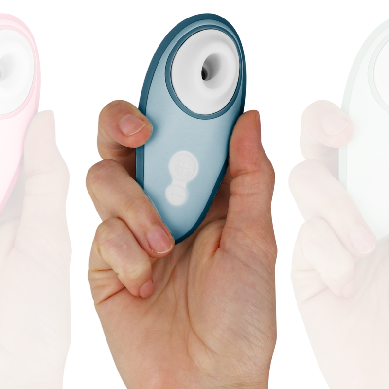 Main présentant de face le Womanizer Liberty 2 bleu acier avec son embout d'aspiration blanc, format de poche pratique pour une stimulation clitoridienne nomade.
