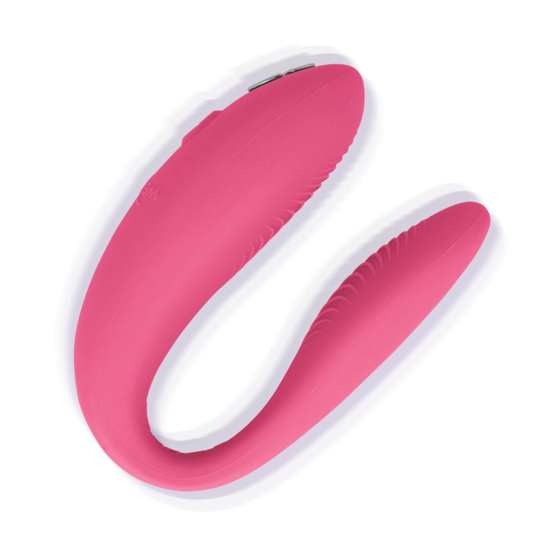 Vibromasseur couple We-Vibe en silicone rose framboise en forme de U, vue trois-quarts isolée sur fond blanc, montrant les deux branches souples à porter pendant les rapports.