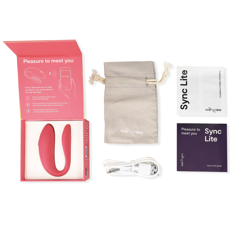 Coffret Sync Lite We-Vibe déballé : vibromasseur couple rose en U en silicone, pochette beige, notices et câble USB, présentés à plat autour de l'écrin du modèle à porter.