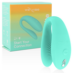 Boîte turquoise We-Vibe Sync à côté du vibromasseur couple en U en silicone vert turquoise, vue trois-quarts montrant les deux branches souples à porter pendant l'amour.