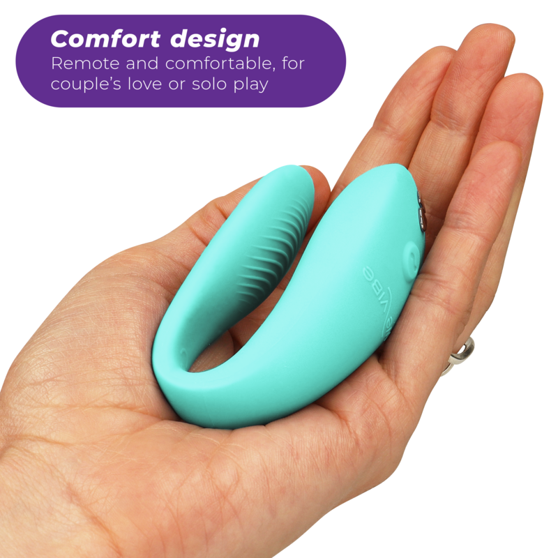 Vibromasseur couple We-Vibe en silicone vert turquoise posé au creux d'une main, vue trois-quarts soulignant sa forme en U compacte à porter discrètement pendant l'amour.
