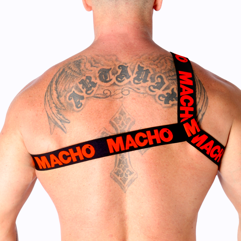 Harnais homme Macho à sangles rouges vu de dos sur dos très tatoué musclé, bandes logo croisées entre les omoplates, soulignant un look fétichiste affirmé et structurant.