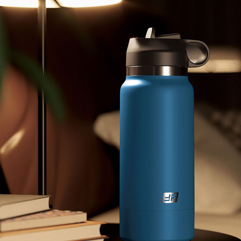 Gourde masturbateur bleue presentee dans une ambiance cosy avec livres, allure de bouteille design qui camoufle son tunnel realiste cyberskin a l'interieur.