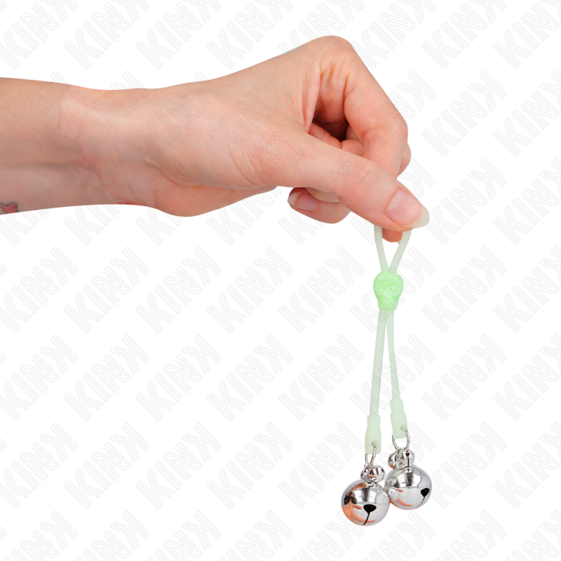 Pince a tetons en silicone vert a billes metalliques tenue entre les doigts, mise en valeur du serrage souple et du lest, accessoire BDSM Kink.