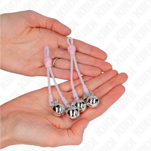 Pinces a tetons en silicone rose a billes metalliques posees au creux des mains, gros plan sur les boucles coulissantes reglables, gamme Kink.