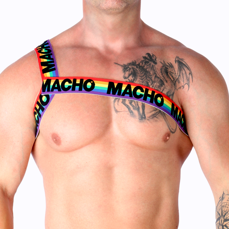 Harnais homme Macho arc-en-ciel porté de face sur torse nu musclé tatoué, sangles colorées épaule et poitrine, soulignant un style fétichiste coloré et un maintien structurant.