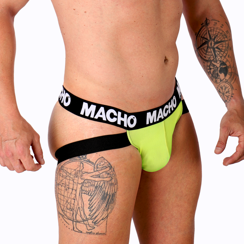 Jockstrap homme vert fluo vu de trois quarts sur hanche tatouée musclée, pochette anatomique et bande logo Macho, valorisant le maintien sensuel et l'extensibilité du lycra.